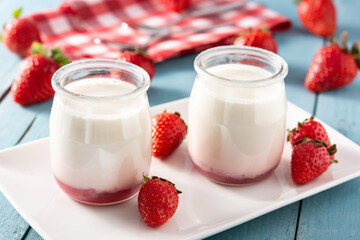 Panna cotta dessert with strawberry on blue wooden table