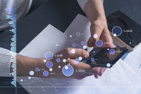 Trader holding in the hands a smart phone and researching stock market to proceed right investment solutions. Internet trading and wealth management concept. Hologram Forex chart over close up shot.