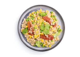 Quinoa porridge with green pea, corn and dried tomatoes on ceramic plate isolated on white background. Top view.