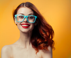 attractive woman with bare shoulders blue glasses red hair cropped view