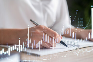 A woman trader in formal wear writing down some ideas to research stock market to proceed right...