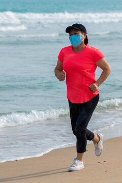 Asian Woman With A Mask Running On The Beach