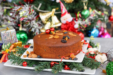 Fototapeta na wymiar Indian Christmas celebration serving homemade Christmas plum cake India Kerala. Fruitcake made of dried fruit, nuts, spices , rum for New Year party, Easter, Christmas Eve
