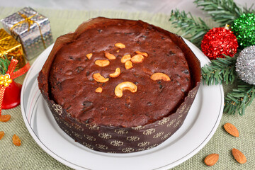Indian Christmas celebration serving homemade Christmas plum cake India Kerala. Fruitcake made of dried fruit, nuts, spices , rum for New Year party, Easter, Christmas Eve