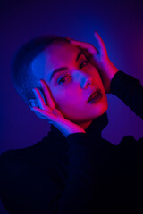 Portrait of a beautiful young woman with short hair in neon light