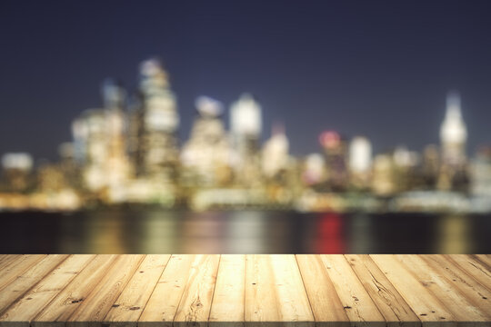 Table top made of wooden dies with blurry city view at dusk on background, template