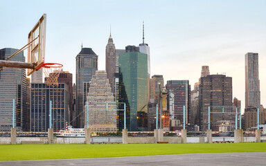 Manhattan skyline seen from sport court at sunset, focus on background, USA.