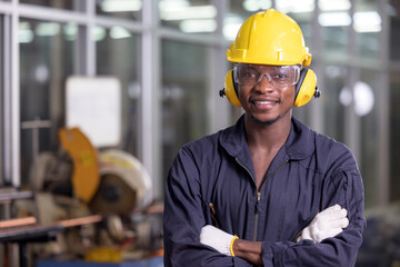 Portrait of cheerful black worker wearing protective headphones posing looking at camera and...