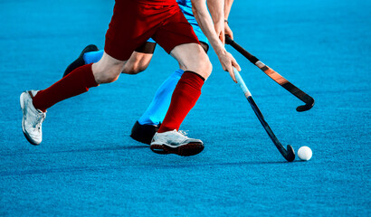 Close up of two field hockey players, challenging eachother for