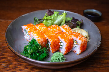 rolls with red caviar, wasabi, nori on a plate. Japanese kitchen