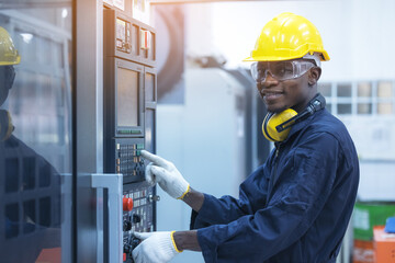 Black man working at programmable machine in factory industries