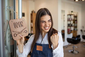 Young woman opening a beauty store and looking very happy - small business concepts. Smiling owner...
