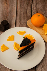 Orange chocolate cakeon a plate with orange fruit commuter.