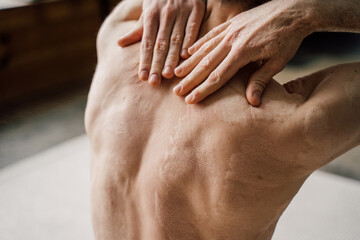 Man with burned back doing massage of his neck and shoulders