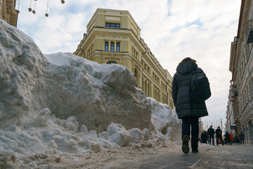 Woman at the cold winter day at the famous Nikolskaya street during coronavirus pandemic after snowy blizzard. Lifestyle concept. Back. Rear view