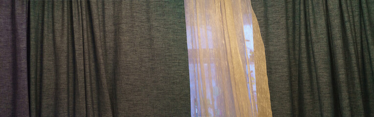 Panorama of the tulle and heavy curtains covered window in the flat. Lifestyles concept.