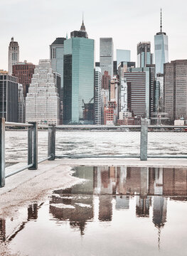 Manhattan skyline with reflection in a puddle, color toning applied, New York City, USA.