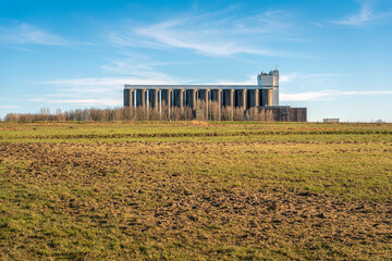 Large storage silos of an animal feed company on the edge of an agricultural area. The photo was taken on a sunny day in the winter season.