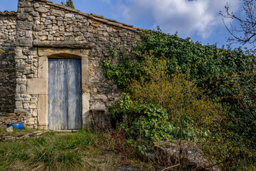 Fototapeta na wymiar wooden door on an old abandoned stone house somewhere in Provence, France