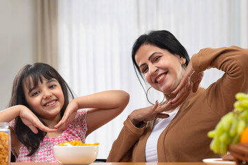 A HAPPY MOTHER DAUGHTER DUO POSING IN FRONT OF CAMERA	