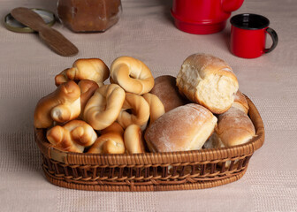 Breads or buns in basket decorated with jam or jelly and coffee