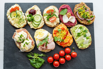 selection board of open sandwiches dips, spreads, cold cut meat, cheese, egg and salad 