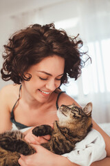 Portrait view of the happy young woman spending time with her cat