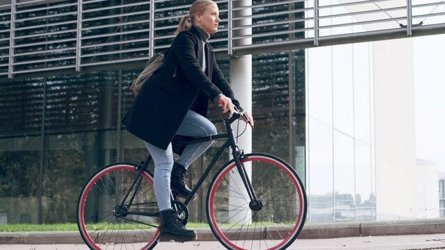 Young woman cycling through city