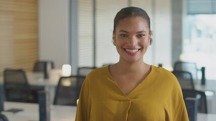 Portrait shot of casually dressed young businesswoman walking into focus in modern open plan start up office and smiling - shot in slow motion - Powered by Adobe