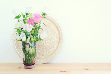 spring bouquet of white and pink bell flowers over wooden table