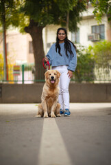 A YOUNG GIRL AND PET DOG LOOKING AT CAMERA AND POSING	