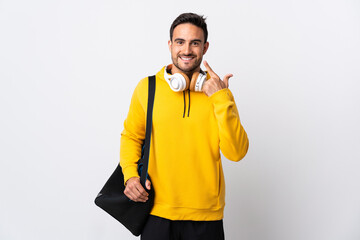 Young sport man with sport bag isolated on white background giving a thumbs up gesture