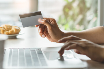 close up shots hands of person shopping on ecommerce and using credit card payment via online banking.