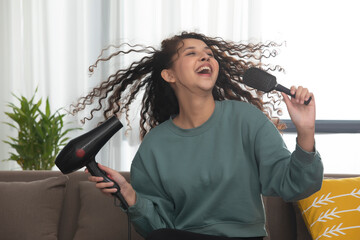 A TEENAGER LAUGHING AND ENJOYING WHILE SITTING AT HOME AND SINGING	