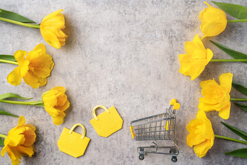 Concept of Mother's day holiday gift shopping with yellow tulip flower on gray background