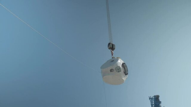 Installation of a wind turbine hub on a gondola using ropes and ropes and a special crane.