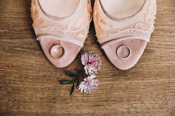 Wedding accessories. On a vintage wooden table are women's shoes with heels with a engagement rings