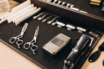 Barber's tools lie on a wooden table next to a mirror