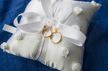love forever, wedding rings on pillow with beautiful and fragrant flowers