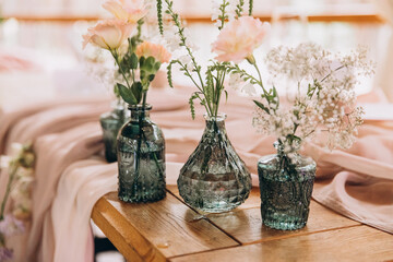 Wedding. Banquet tables are decorated with fabric and flower arrangements in vintage bottles