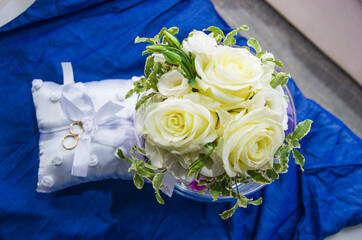 love forever, wedding rings on pillow with beautiful and fragrant flowers