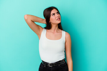 Young caucasian woman isolated on blue background suffering neck pain due to sedentary lifestyle.