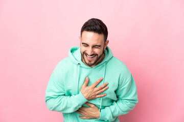 Young caucasian handsome man isolated on pink background smiling a lot