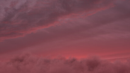 Obraz premium view to red sunset sky with fluffy clouds