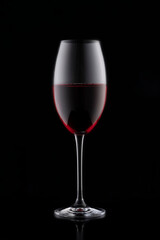 a glass of red wine on a black background