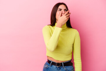 Young caucasian woman isolated on pink background laughing happy, carefree, natural emotion.