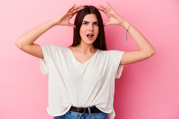 Fototapeta premium Young caucasian woman isolated on pink background celebrating a victory or success, he is surprised and shocked.