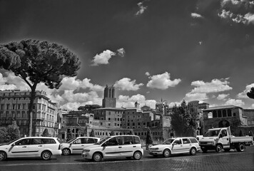 Row of white cars on cobblestone pavement