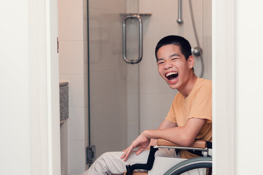 Happy asian disabled on wheelchair smiling with happiness face in toilet, Real people pictures of daily life in the home, Lifestyle of disability kid concept.