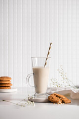 Glass of milk with homemade cookies on a white background. Breakfast and healthy food concept. white on white